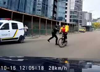 В Киеве полицейский толкнул курьера на велосипеде, тот упал под колеса авто | ВИДЕО