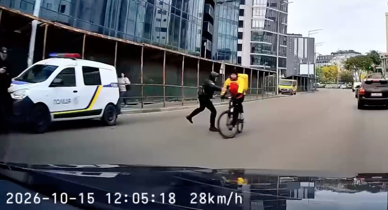 В Киеве полицейский толкнул курьера на велосипеде, тот упал под колеса авто | ВИДЕО
