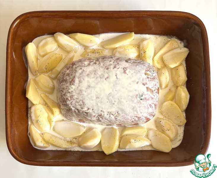 Мясной хлебец в окружении ломтиков картофеля