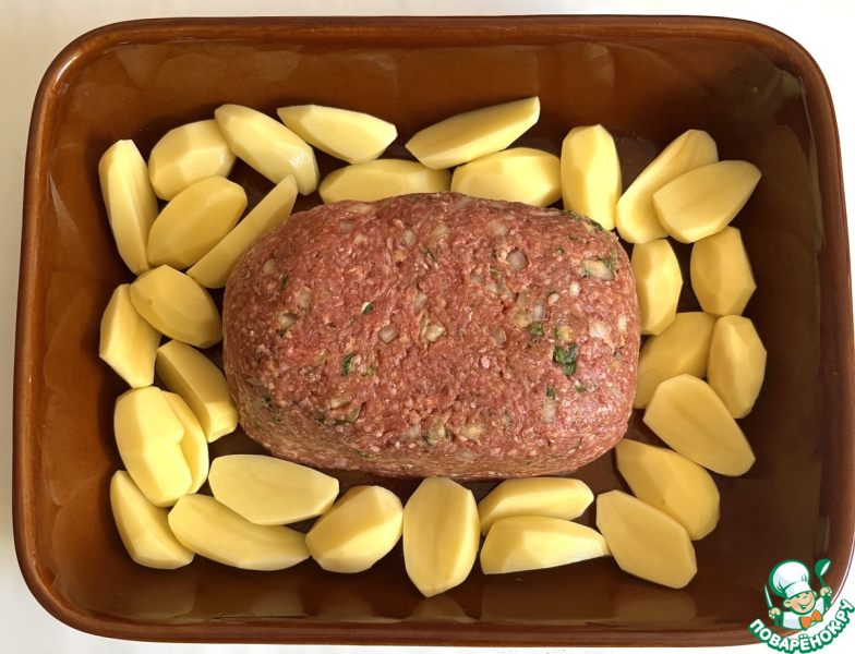 Мясной хлебец в окружении ломтиков картофеля